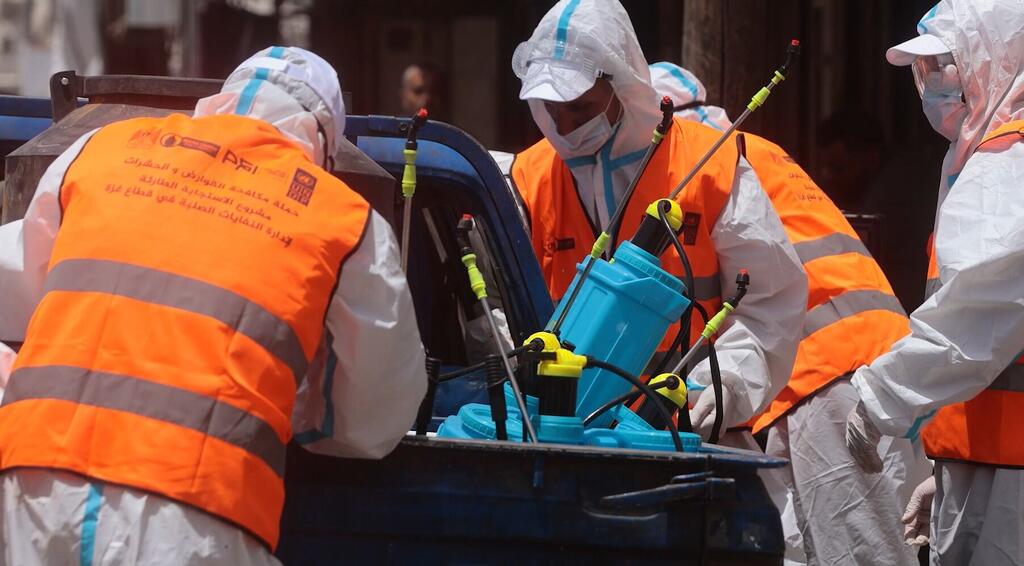 Des équipes du PNUD et des partenaires locaux menant une campagne de lutte contre les rongeurs et les insectes sur le site d'accumulation des déchets dans la zone du marché de Firas, à Gaza.